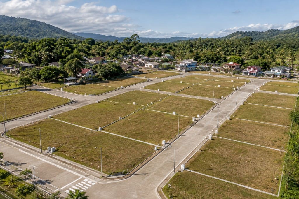 Aerial view of a new Philippine subdivision with paved roads and empty lots ready for homes